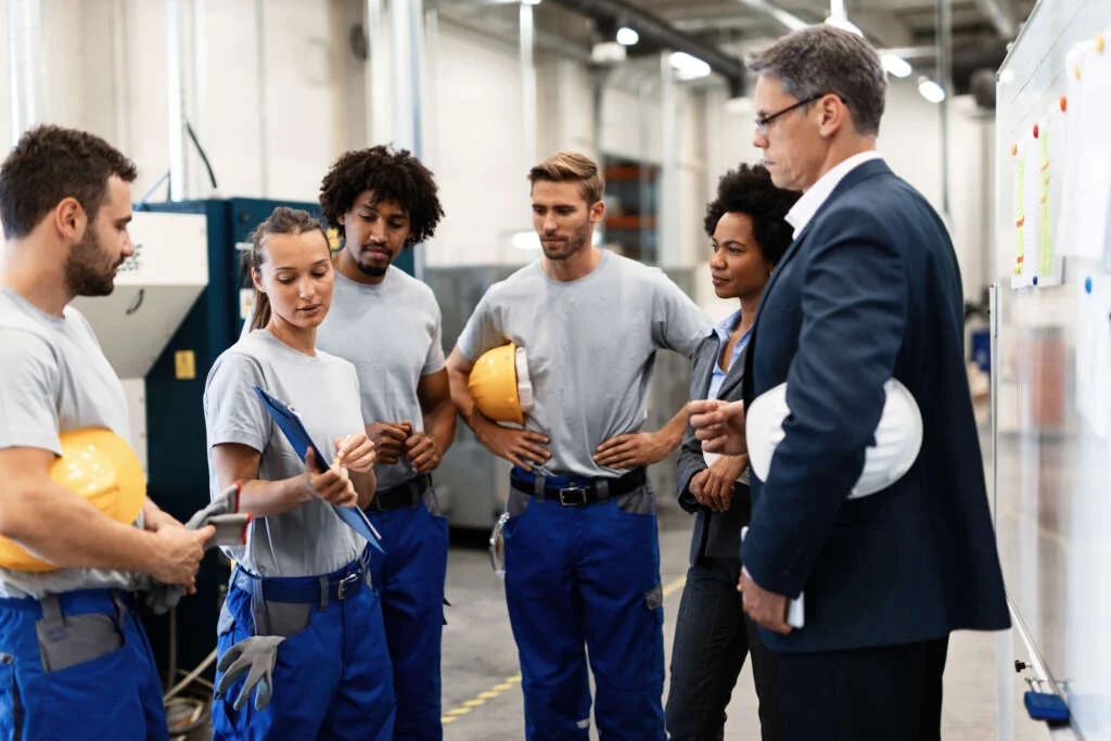 Group workers having meeting with company managers factory focus is female worker is presenting development reports 1